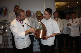 Guillaume Gomez, président des Cuisiniers de la République, remet son trophée à Jason Nicoviotis.