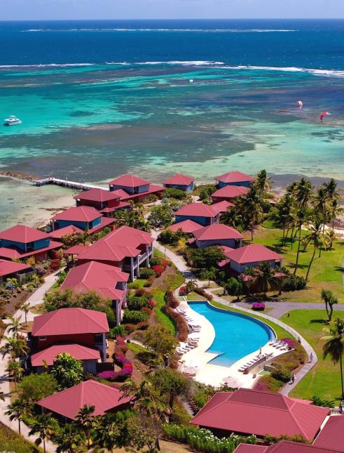 Vue du ciel de l'Hôtel Cap Est : 18 villas comportant 50 suites, un jardin arboré de 5 hectares, une piscine à débordement de 40 mètres, sans oublier, le lagoon bleu turquoise de la mer des Caraibes tout autour avec sa plage privative.