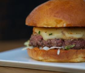 Le Aspen : steak de boeuf, raclette fumée, compotée d'oignons et lardons, iceberg.