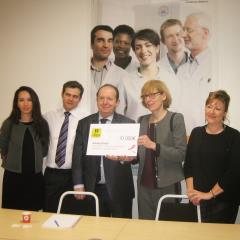 Remise du cheque à la Ligue contre le cancer par la FIL, par Thierry Amirault (au centre).