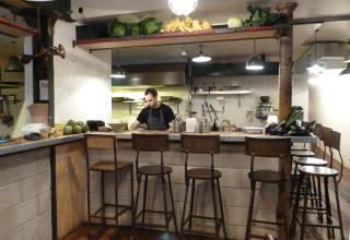 Le bar offre une vue directe sur les cuisines et les légumes frais prêts à être cuisinés.