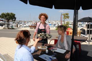 Nathalie Delecrin dit La Jane en plein service sur la terrasse face au port de l'herbaudière