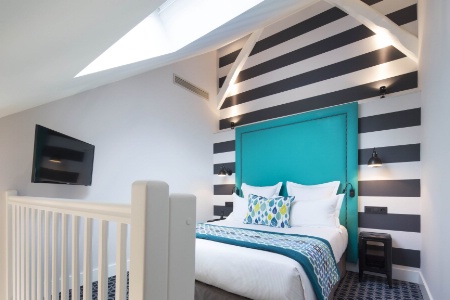 Textile : le sol, le jet de lit et un coussin rappellent la couleur bleue mise en avant avec la tte de lit. L'Htel Fabric  Paris.