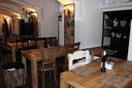 1 - Cococo - des tables de bois clair et des chaises dpareilles.
