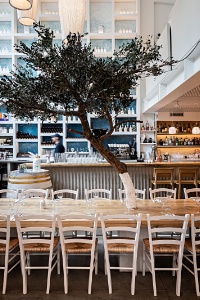 Une dco bleue et blanche, un immense bar, une table d'htes et l'olivier symbolique.